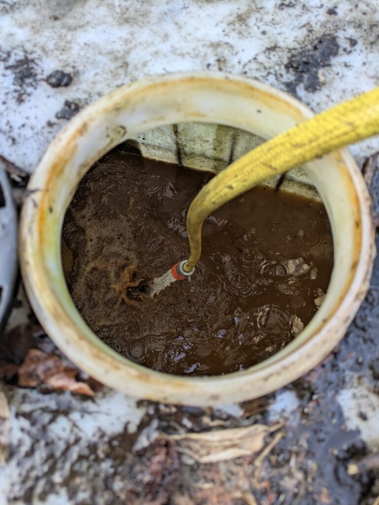 Schlamm im IBC wird mit Wasser ausgespült